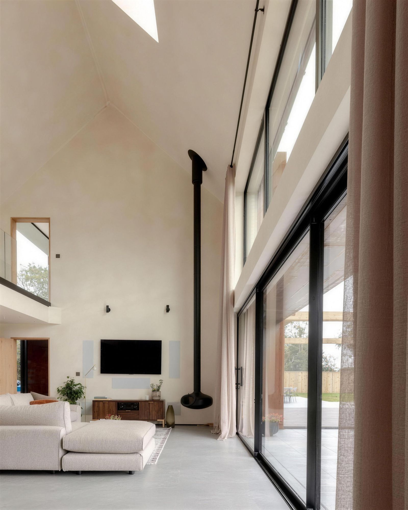 Double-height limewash living room with black-framed windows