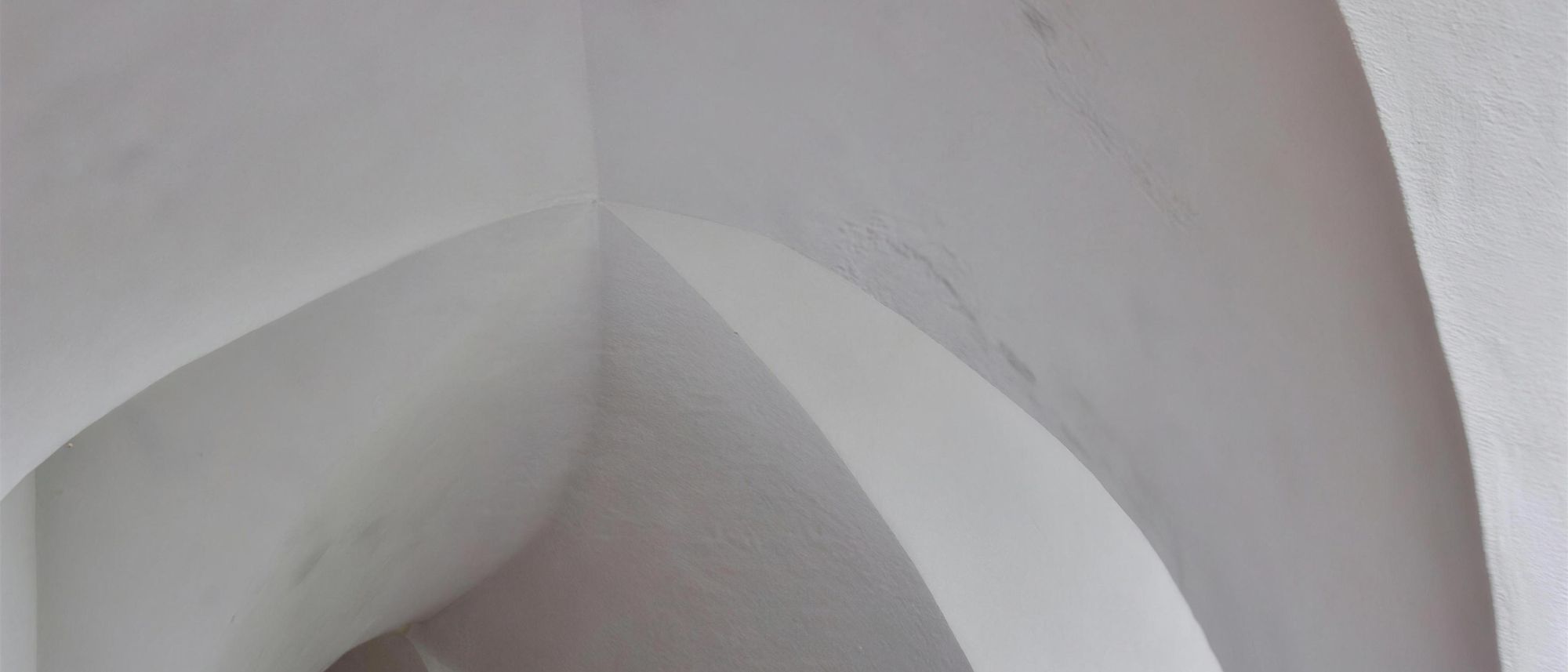 White plaster vaulted ceiling with smooth, crisp arches