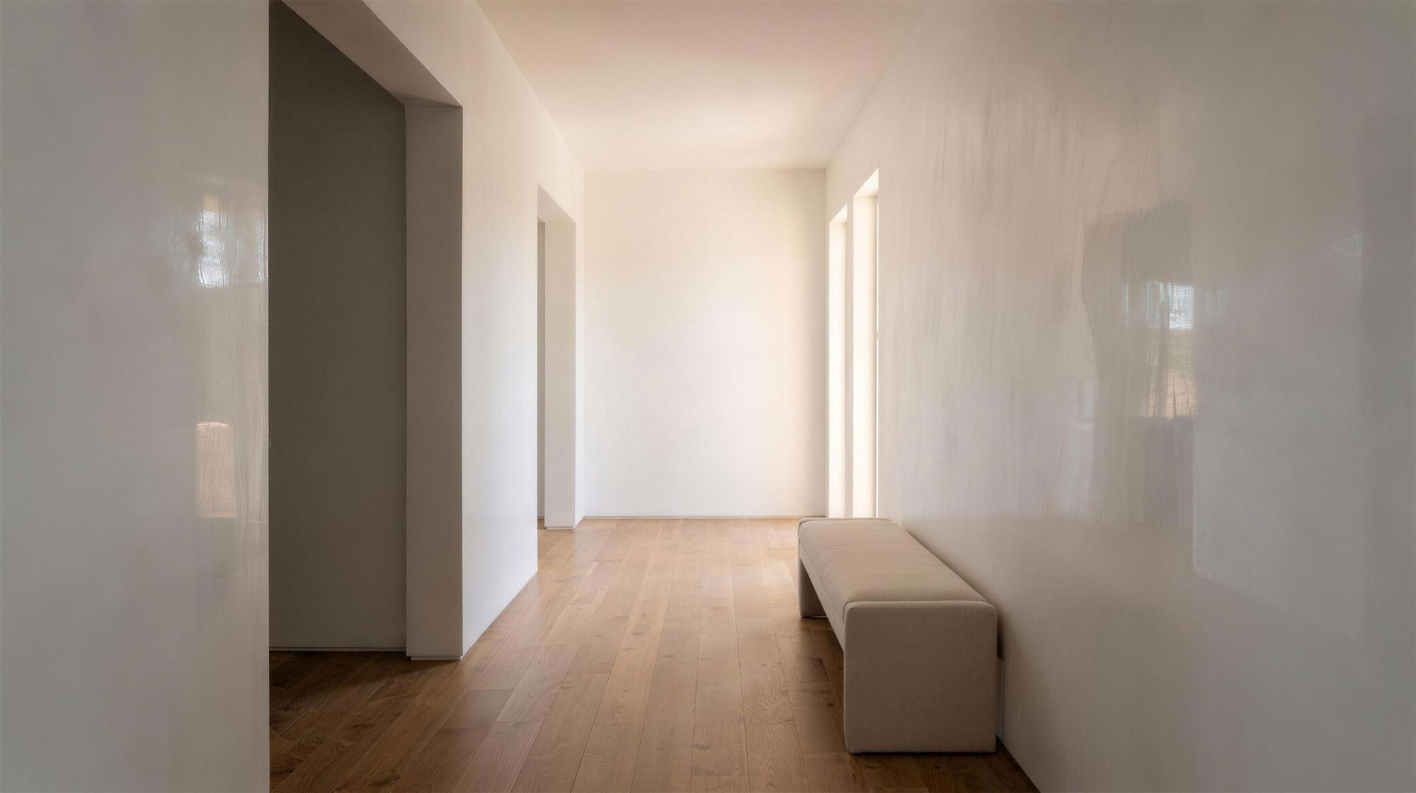 Hallway with smooth, high-sheen white polished plaster walls catching soft daylight
