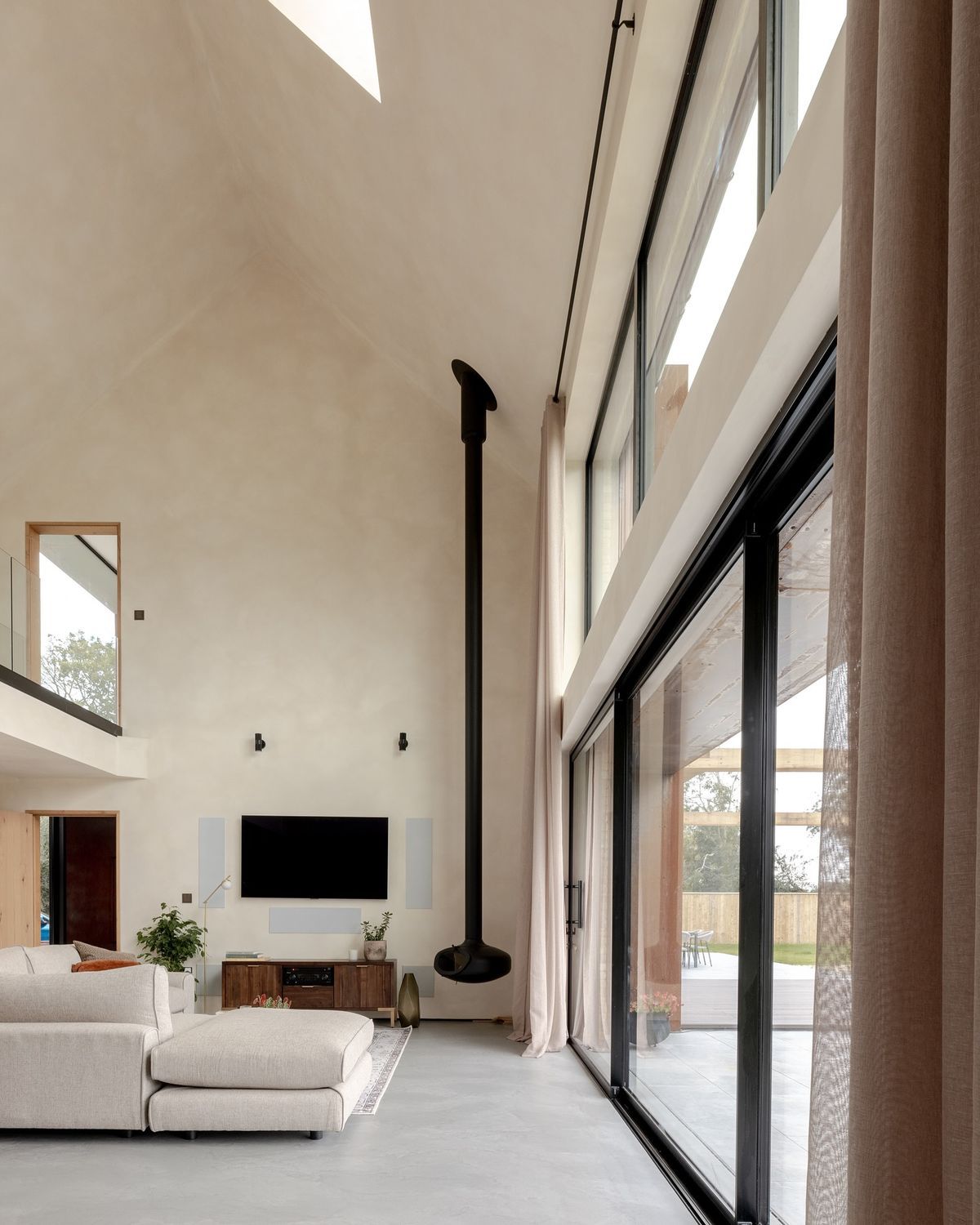 Limewash accent wall in a high-ceiling living room
