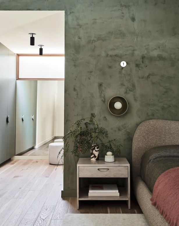 Sage green plaster wall with a soft, cloud-like texture in a modern hallway